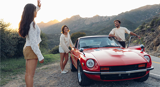 Person greeting friends coming out of a sports car